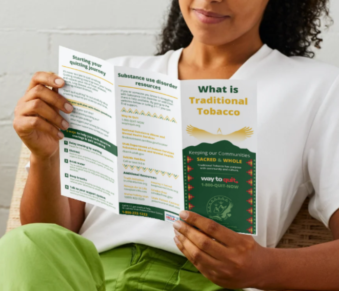 A woman reading a brochure about traditional tobacco.